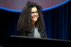 April Baskin smiles while standing at a podium